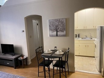 A black chair sits in front of a table with a plate on it.